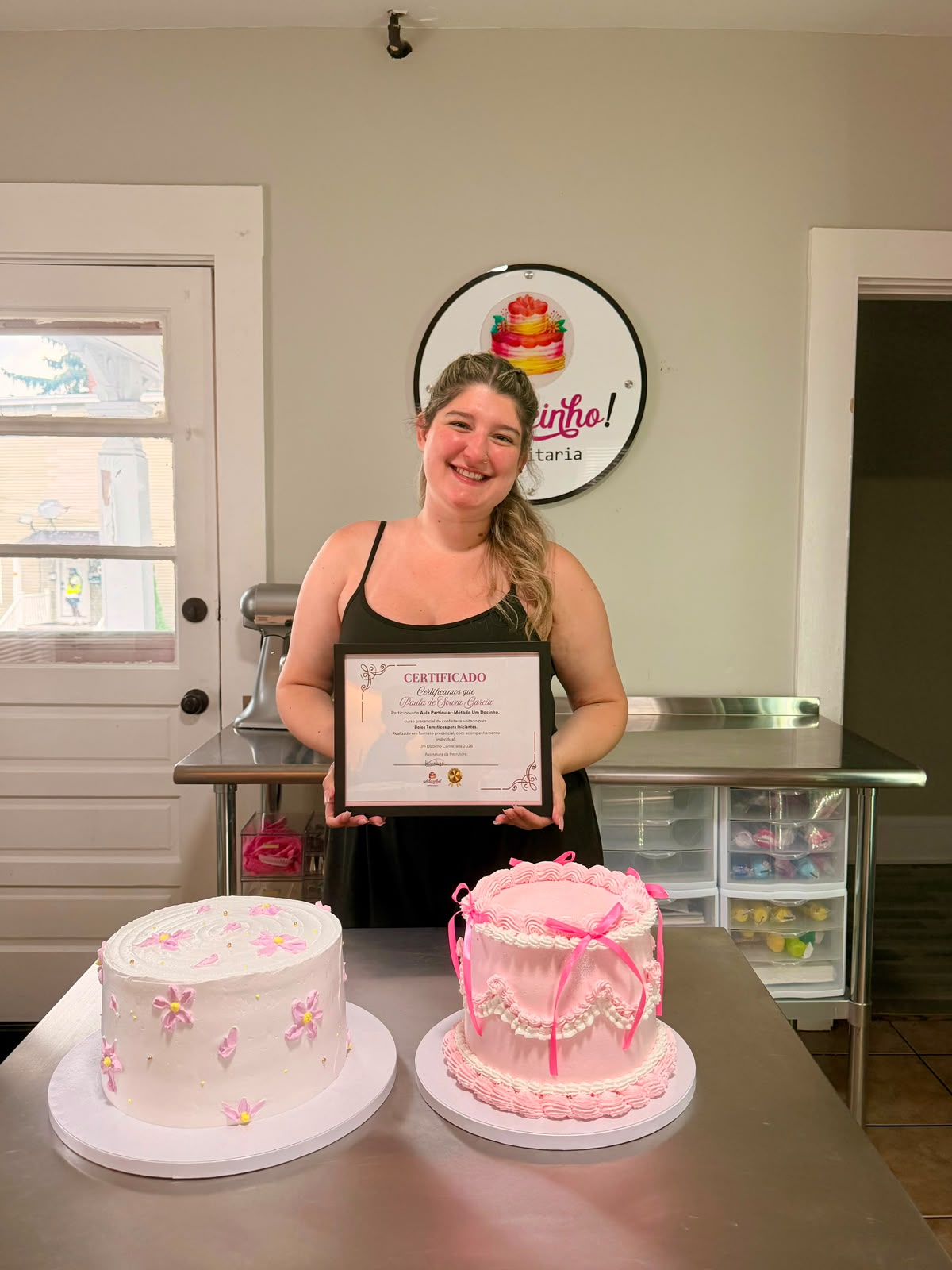Paula com o certificado do Método Um Docinho e seus dois bolos finalizados